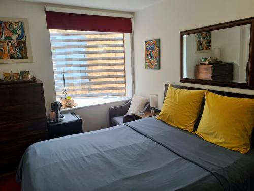a bedroom with a bed with yellow pillows and a window at Superb Guest Room in London