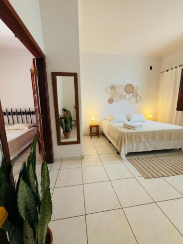 a bedroom with a bed and a mirror on the wall at Jeromia Casa e Pousada in Rifaina