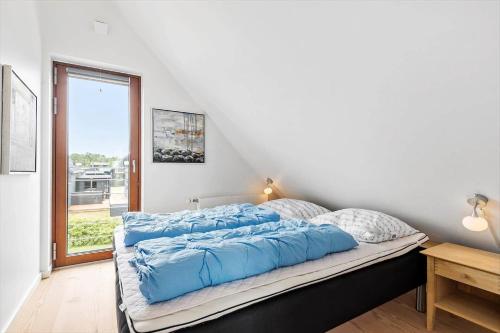 a bed with blue pillows on it in a bedroom at 0343-Romo-Vestergade-329 in Høm