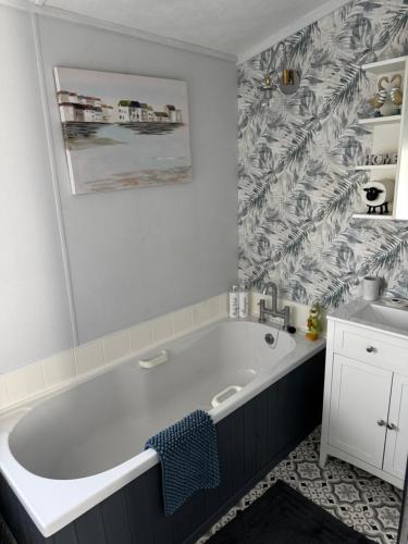 a bathroom with a large tub and a sink at 21 Hesket Park HUGE HOT TUB Pet friendly No Commercial Vans in High Hesket