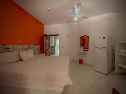 a bedroom with a white bed and a refrigerator at Royal Pacífico Manzanillo in Manzanillo