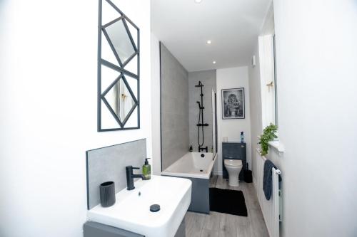 a white bathroom with a sink and a toilet at Limefield Residence in West Calder