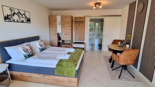 a bedroom with a bed and a table and a desk at Ferienwohnung Naturgenuss in Oy-Mittelberg