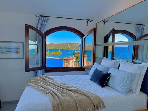 a bedroom with a bed with a view of the ocean at Villa Azzurra in Cannigione