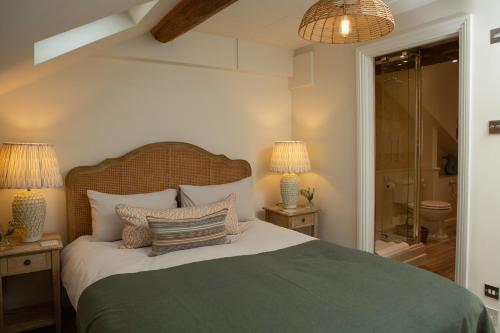 a bedroom with a bed with two night stands and two lamps at The Cottage - Elegant 3 Bedroom Cottage in the Heart of Stow-on-the-Wold in Stow on the Wold