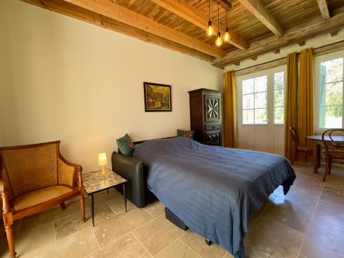 a bedroom with a bed and a chair and a table at Clos de La Brelaisière in Chauvigny