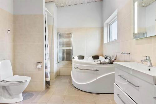 a bathroom with a tub and a toilet and a sink at 0342-Romo-Vestergade-355 in Høm