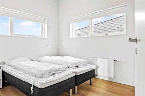 a bed sitting in a room with two windows at 0342-Romo-Vestergade-355 in Høm