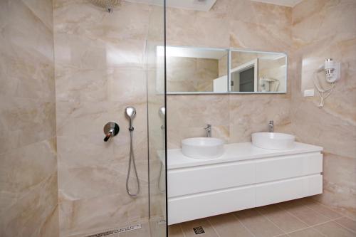 a bathroom with two sinks and a shower at Sunset Apartments in Makarska