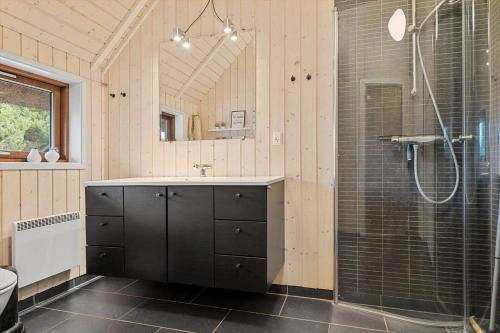 a bathroom with a shower and a sink and a mirror at 0212-Romo-Lejrbjergvej-24 in Høm