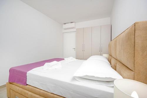 a bedroom with a large bed with white sheets at Sunset Apartments in Makarska