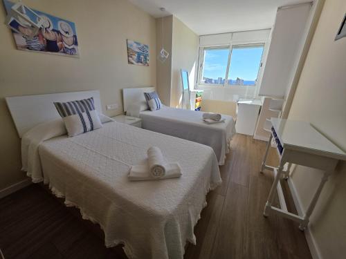 a hotel room with two beds with towels on them at Apartamento Luxury Views IF Benidorm in Benidorm