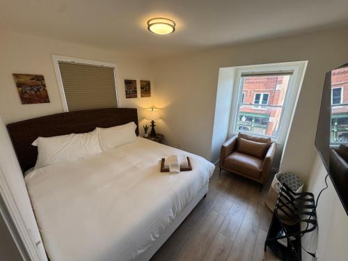 a bedroom with a bed and a chair and a window at The Global Getaway in St. Charles