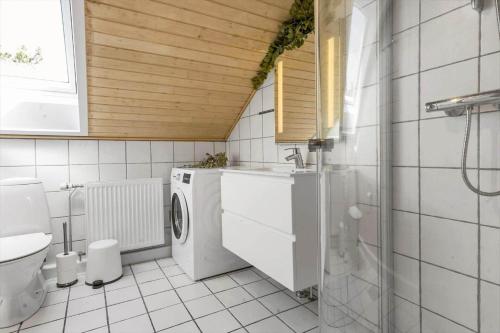 a bathroom with a sink and a washing machine at 0442-Romo-Vestergade-137-Ap-101 in Høm