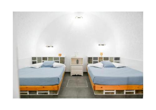 a bedroom with two beds and a sink at Kafieris Blue in Firostefani