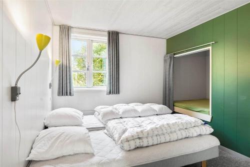 a bedroom with two beds and a green wall at 0227-Romo-Kromosevej-17 in Høm