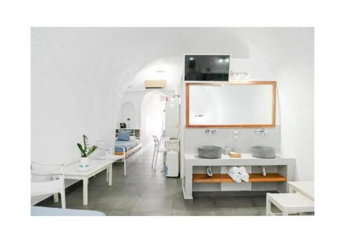 a white bathroom with a sink and a table at Kafieris Blue in Firostefani