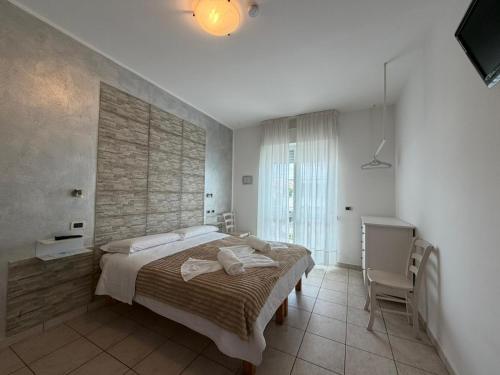 a bedroom with a large bed and a desk at Hotel Villa Cesare B&B in Alba Adriatica