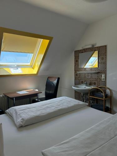 a bedroom with a bed and a sink and a mirror at Pension Grübel in Lindau