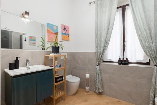 ein Badezimmer mit Waschbecken, Toilette und Fenster in der Unterkunft Vicolo 6 in Bollate