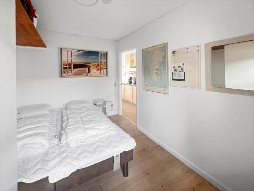 a white bedroom with a bed in a room at 0263-Romo-Lyngvejen-99-Ap-28 in Høm