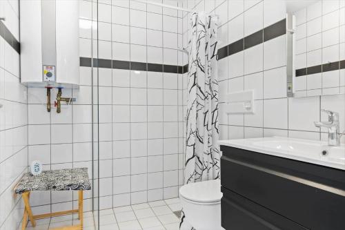 a white bathroom with a toilet and a sink at 0456-Romo-Vestergade-227-Ap-15 in Høm