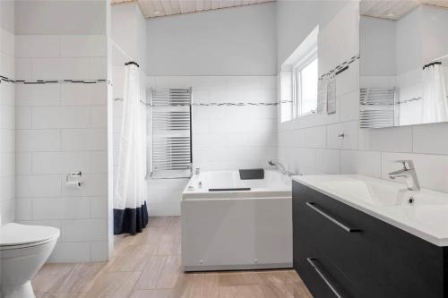 a white bathroom with a sink and a toilet at 0347-Romo-Vestergade-353 in Høm