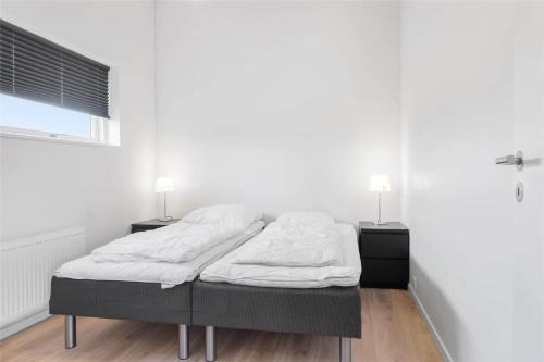 a bed in a room with two night stands and two lamps at 0347-Romo-Vestergade-353 in Høm