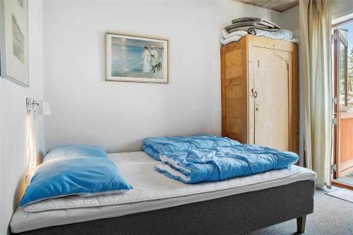 a bed with blue pillows on it in a room at 0265-Romo-Lyngvejen-99-Ap-18 in Høm