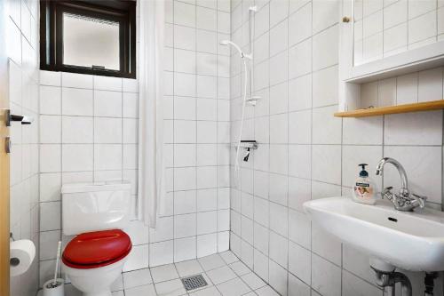 a bathroom with a red toilet and a sink at 0265-Romo-Lyngvejen-99-Ap-18 in Høm