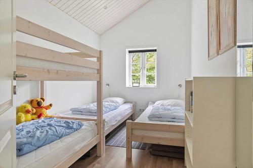 a bedroom with two bunk beds and a window at 0130-Romo-Ejnar-Mikkelsensvej-22 in Høm