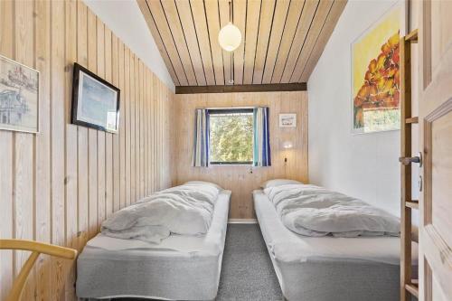 two beds in a small room with a window at 0321-Romo-Stormengevej-4 in Høm