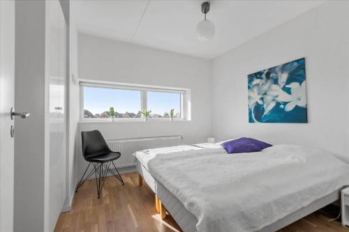 a bedroom with a bed and a chair in it at 0277-Romo-Hollaenderstraedet-38 in Høm