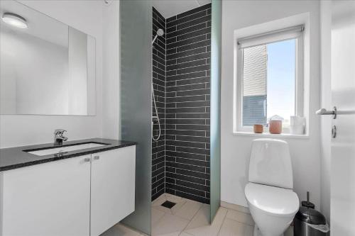 a bathroom with a toilet and a sink and a window at 0277-Romo-Hollaenderstraedet-38 in Høm