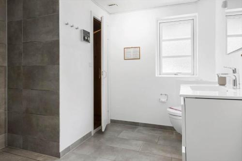 a bathroom with a toilet and a sink and a window at 0339-Romo-A-Hveyselsvej-32 in Høm