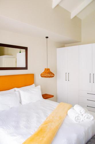 a bedroom with a white bed and a mirror at Rustic Hills No 3 Self Catering in Swakopmund
