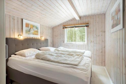 a bedroom with a bed with white sheets and a window at 0424-Romo-Sonderstrandvej-15 in Høm