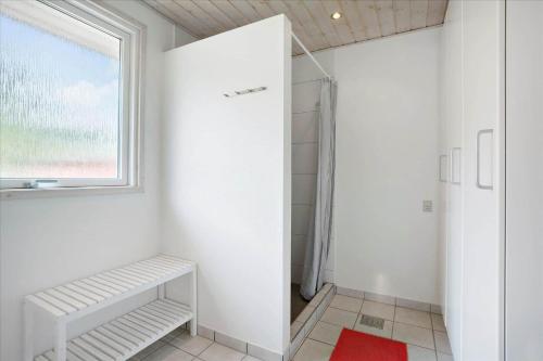 a white bathroom with a shower and a window at 0424-Romo-Sonderstrandvej-15 in Høm