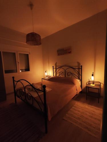 a bedroom with a bed with two lights on it at SEA VIEW in Nea Skioni