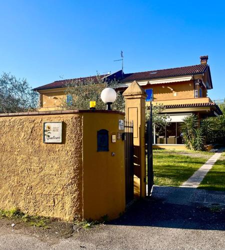 a yellow building with a door in front of a house at Sunflower Guest House in Carrara