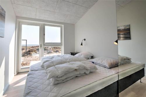a white bedroom with a large bed and a window at 0226-Romo-A-M-Listsvej-4 in Høm