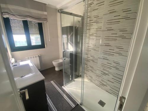a bathroom with a glass shower with a sink at Chalet Bordones Playa in Bordons