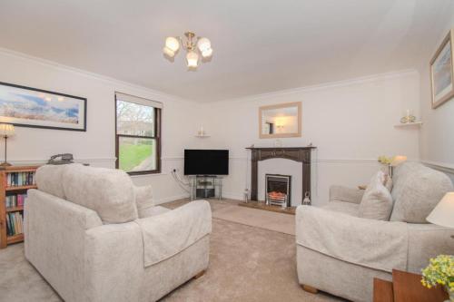 a living room with two chairs and a fireplace at Aura in Keswick