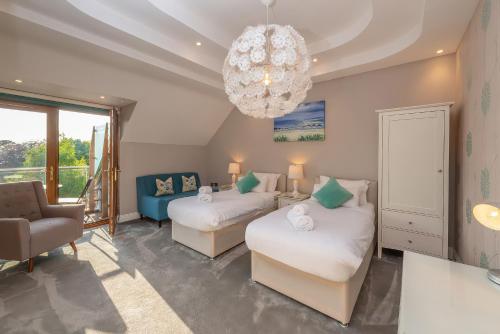 a bedroom with two beds and a chandelier at Hamble House in Southampton