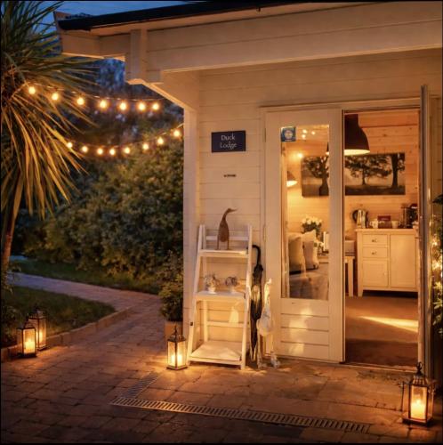 a house with a porch with lights and a door at Duck Lodge B&B in Pyecombe