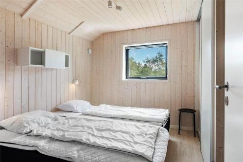 a bedroom with two beds and a window at 0340-Romo-Dvaergternen-2 in Høm