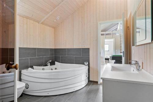 a large bathroom with a large tub and two sinks at 0340-Romo-Dvaergternen-2 in Høm