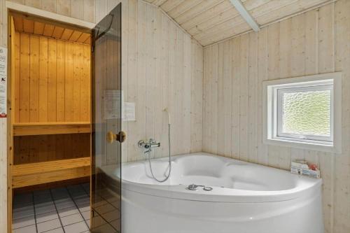 a white tub in a bathroom with a window at 0223-Romo-Sonderstrandvej-12 in Høm