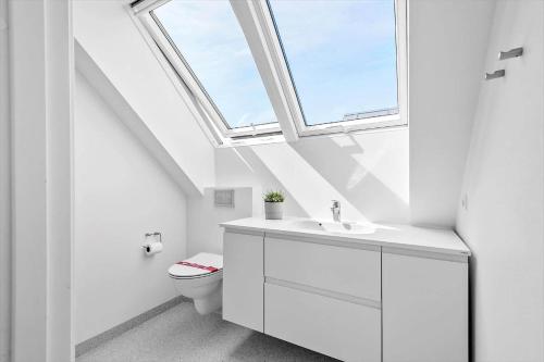 a bathroom with a toilet and a window at 0433-Romo-Vestergade-345 in Høm