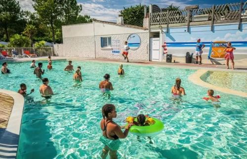 a group of people in the water at a swimming pool at ZEcamping animations espace aquatique piscine couverte et restaurant in Saint-Hilaire-de-Riez